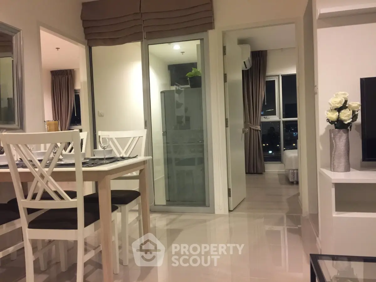 Modern open-plan living and dining area with elegant decor and city view.