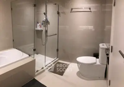 Modern bathroom with glass shower and bathtub in luxury apartment.