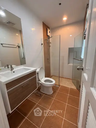 Modern bathroom with glass shower and stylish vanity in a contemporary home.