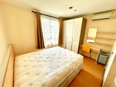 Bright and cozy bedroom with large window and modern furnishings in a stylish apartment.