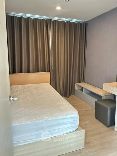 Modern bedroom with wooden flooring and stylish curtains in a cozy apartment.