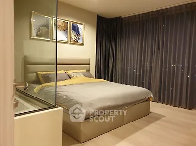 Luxurious bedroom with modern decor and floor-to-ceiling windows offering stunning city views.