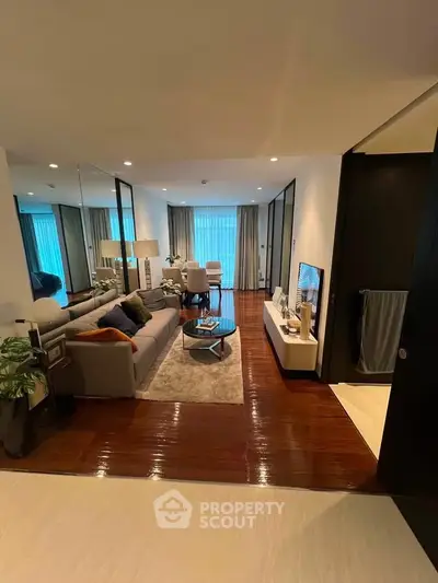 Modern living room with stylish decor and large windows offering natural light.