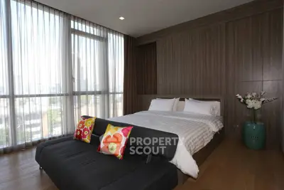 Modern bedroom with large windows and stylish decor in a luxury apartment.