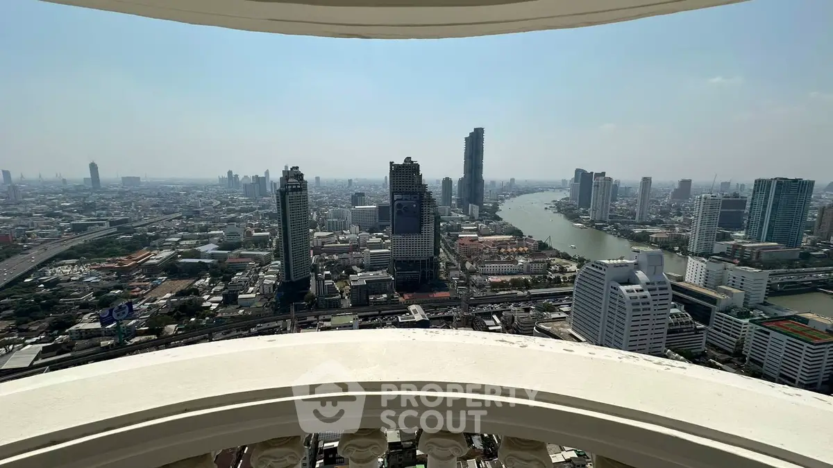 Stunning cityscape view from a high-rise balcony overlooking a river and skyline.