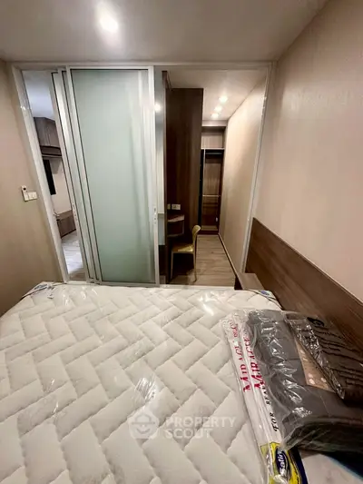 Cozy bedroom with modern sliding door and comfortable mattress in stylish apartment.