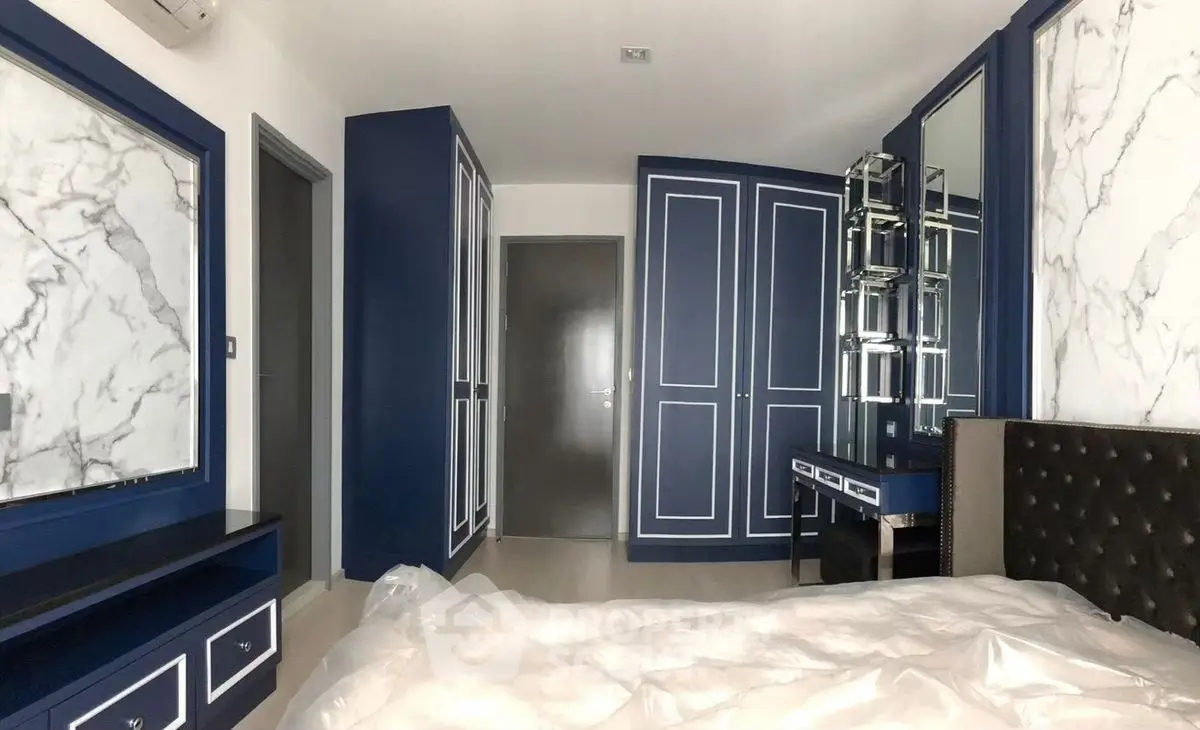 Luxurious bedroom with elegant blue and white decor, featuring a stylish vanity and ample storage space.
