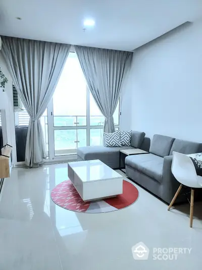 Modern living room with large window and stylish furniture in a high-rise apartment.