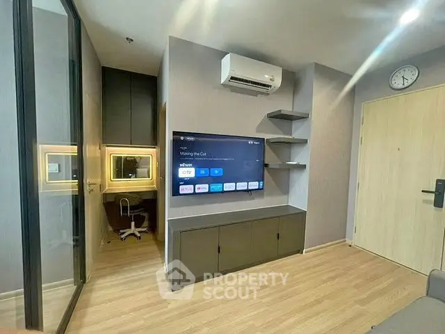 Modern living room with wall-mounted TV and air conditioning in a stylish apartment.