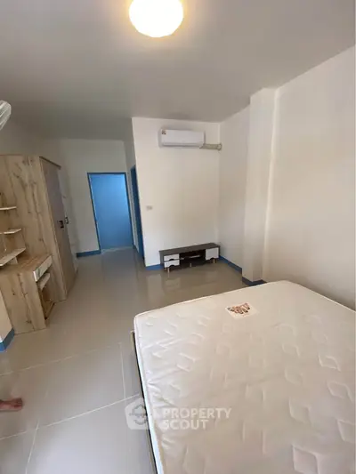 Spacious bedroom with modern furnishings and air conditioning in a bright apartment.