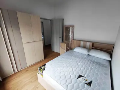 Modern bedroom with wooden furniture and a comfortable bed in a stylish apartment.