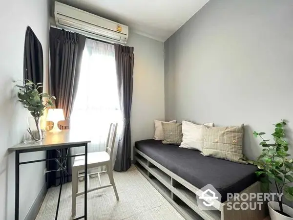 Cozy and well-lit corner unit with a comfortable daybed, modern decor, and lush greenery, perfect for relaxation and urban living.