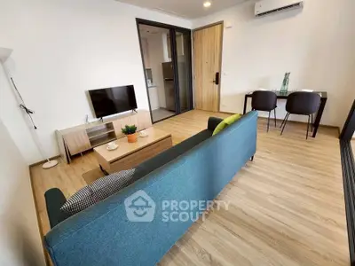 Modern living room with stylish furniture and open layout, featuring a cozy sofa and wall-mounted TV.