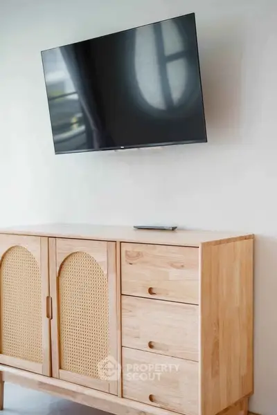 Modern living room with stylish wooden cabinet and wall-mounted TV, perfect for contemporary interiors.