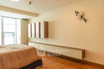 Spacious modern bedroom with wooden flooring and minimalist decor