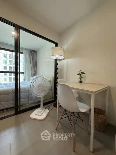 Cozy study area with modern furniture and view into a stylish bedroom in a contemporary apartment.