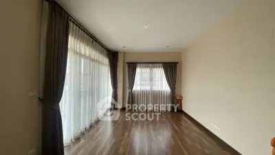 Spacious empty room with large windows and elegant curtains, perfect for customization.