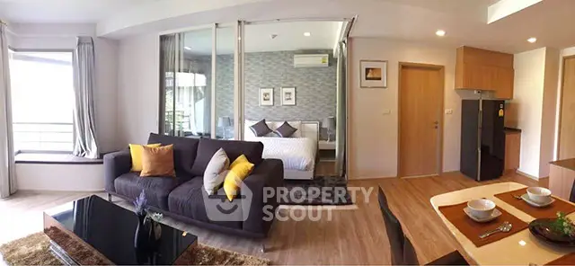Modern open-plan living room with stylish decor and cozy bedroom view