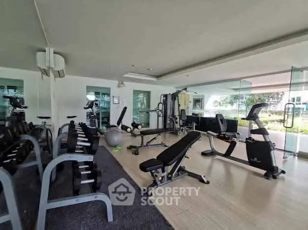 Modern gym with state-of-the-art fitness equipment and large windows for natural light.