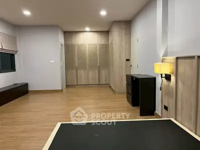 Spacious bedroom with modern wooden flooring and built-in wardrobe