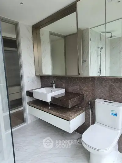 Modern bathroom with sleek design and marble finishes in luxury apartment.