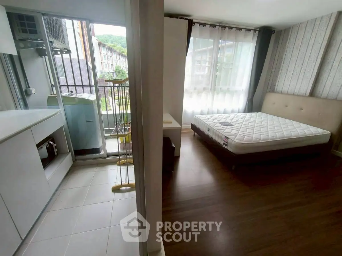 Modern apartment with bedroom and laundry area, featuring natural light and stylish design.
