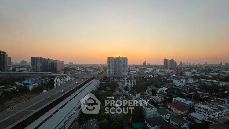 Stunning cityscape view at sunset with high-rise buildings and highway, perfect for urban living.