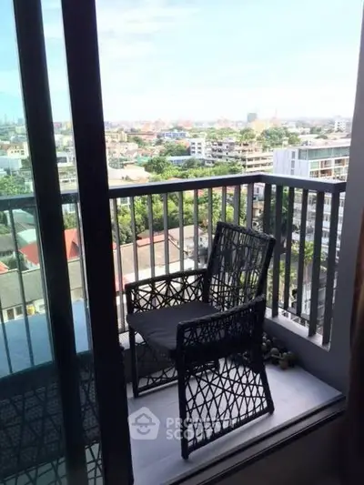 Charming balcony with city view and stylish wicker chair, perfect for relaxation.