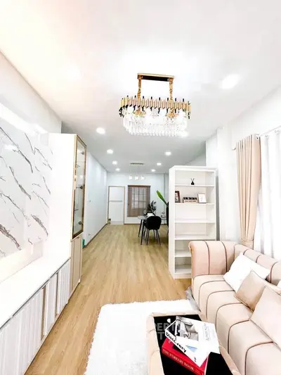 Spacious and elegant living room with modern chandelier and cozy seating area.