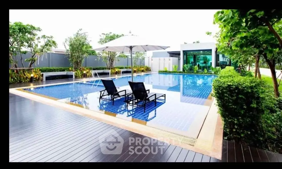 Luxurious outdoor pool area with modern design and lush greenery, perfect for relaxation and leisure.