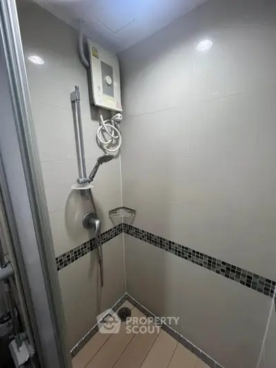 Modern bathroom shower area with sleek tiles and water heater