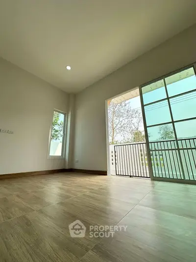 Spacious empty room with large windows and balcony access, perfect for customization.