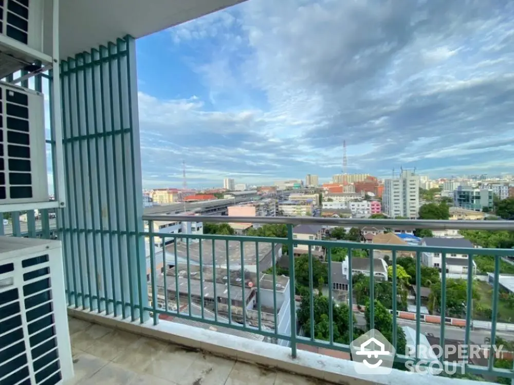 Expansive cityscape views from a spacious balcony in a high-rise apartment, featuring safety railings and ample space for outdoor relaxation.