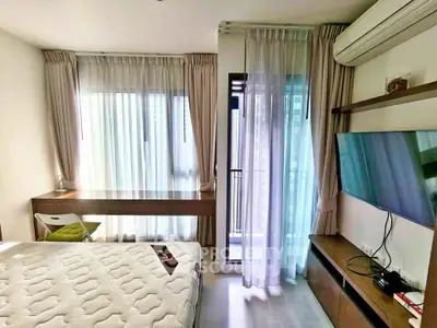 Modern bedroom with large windows, air conditioning, and wall-mounted TV, featuring a cozy bed and stylish decor.