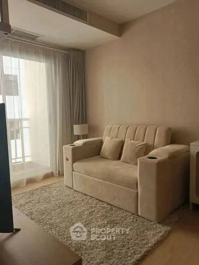 Cozy living room with plush beige sofa and soft rug, perfect for relaxation.