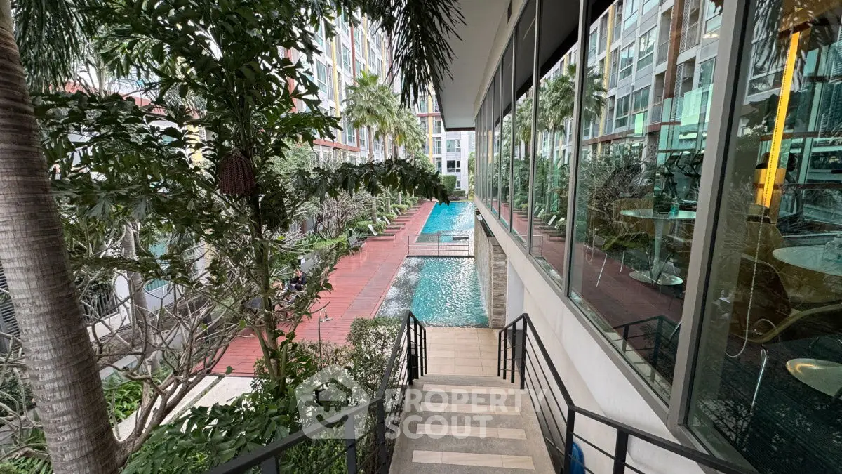 Luxurious condo with pool view and lush greenery, perfect for relaxation and leisure.