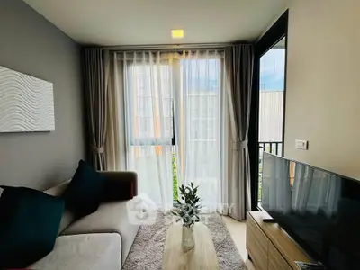Cozy living room with modern decor and large window offering natural light.