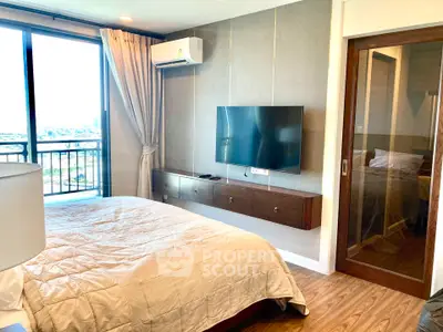 Modern bedroom with large window and wall-mounted TV in a stylish apartment.