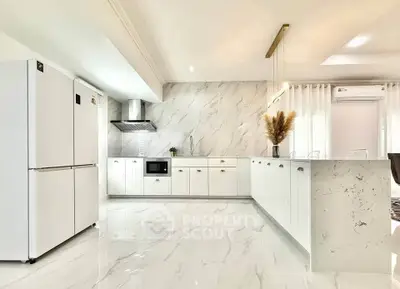 Modern kitchen with sleek white cabinets and marble backsplash