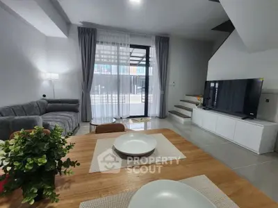 Modern living room with stylish decor and large TV, perfect for relaxation and entertainment.