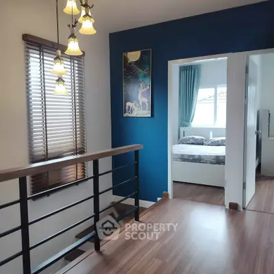 Stylish modern interior with wooden flooring and elegant lighting, featuring a cozy bedroom and artistic decor.