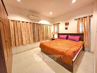 Spacious bedroom with cozy decor and ample natural light, perfect for relaxation.