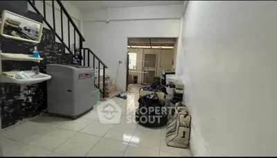 Spacious storage area with tiled flooring and staircase, ideal for organizing essentials.