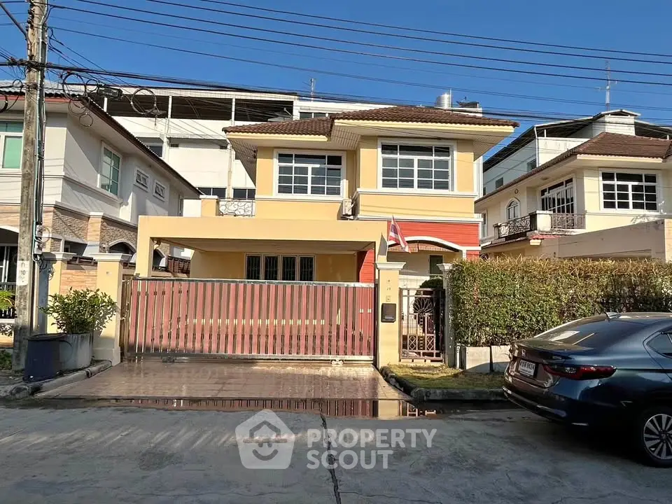 Charming two-story house with gated entrance and driveway in a suburban neighborhood.