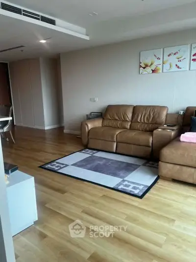 Spacious living room with modern leather sofa and elegant wooden flooring