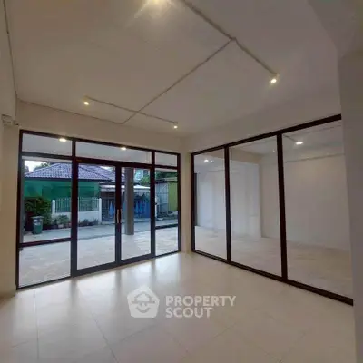 Spacious modern room with large glass doors and tiled flooring