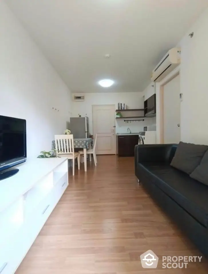 Modern living room with sleek furniture and open kitchen layout, perfect for cozy urban living.