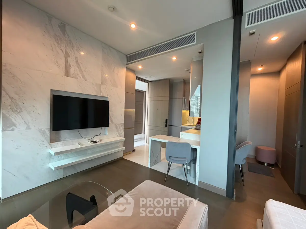 Modern living room with sleek marble wall, mounted TV, and stylish furniture in a contemporary apartment.