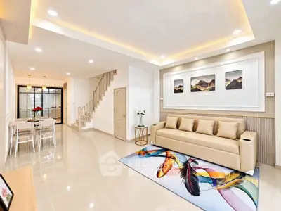 Modern living room with elegant decor and open layout, featuring a stylish sofa and vibrant feather-themed rug.
