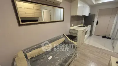 Modern compact apartment with kitchenette and cozy living area, featuring sleek design and efficient use of space.